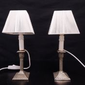 A pair of silver plated candlesticks with faux candle light fittings. H.36cm