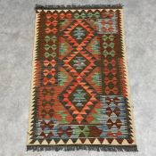 An Afghan Kilim flatweave rug with an allover geometric polychrome design. 126x79cm.