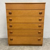 A mid-century teak dressing chest of drawers with hinged top enclosing a fitted interior with