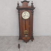 A C.1900 mahogany Vienna Regulator wall clock with shaped pediment over the enamelled dial flanked
