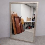 A large contemporary mirror with rectangular bevelled plate in a silvered faux studwork frame. L.180
