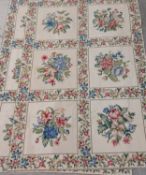 A pair of needlepoint rugs with floral bouquets withing foliate panels. L.183 W.120cm