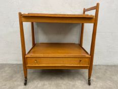 A mid century teak tea or drinks trolley with lift off tray top and maker's label to the