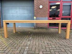 A very large contemporary oak farmhouse style dining table with solid plank top raised on heavy