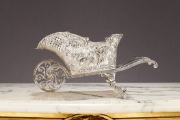A GERMAN SILVER NOVELTY BOTTLE HOLDER IN THE FORM OF A WHEELBAROW C. 1890