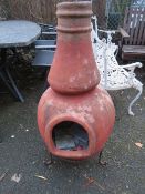 A large terracotta chiminea and stand