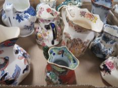A tray of assorted ceramic jugs to include Masons together with a tray of glassware and a tray of