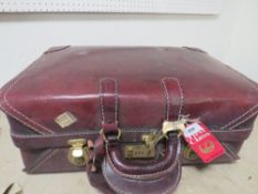 A vintage lined red leather suitcase
