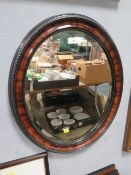 A vintage oval bevelled and framed mirror