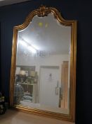 A gilt framed bevel edge wall mirror with serpentine top, H 103 cm, W 65 cm