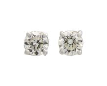A pair of 18k white gold diamond solitaire stud earrings.