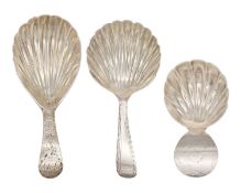 A selection of three George III silver caddy spoons with scallop shell bowls and bright cut handles.