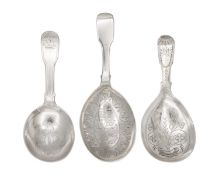 A selection of three Georgian silver caddy spoons with bright cut decoration.