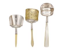A selection of three George III silver caddy spoons with scoop-shaped bowls.