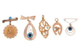A group of jewellery to include; three greek brooches; the largest featuring a stylised bow plaque w