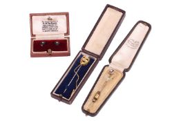 A diamond set theatrical 'comedy' mask stick pin, with Italian control marks and stamped '750', with