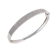 A 9 CARAT GOLD DIAMOND SET HINGED BANGLE