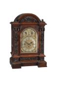 A LATE VICTORIAN CARVED OAK QUARTER-CHIMING BRACKET CLOCK