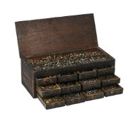 A SMALL DRAWER CABINET CONTAINING A LARGE COLLECTION OF SCREWS FOR USE IN CLOCK RESTORATION