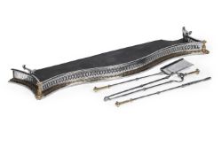 A POLISHED STEEL AND BRASS MOUNTED SERPENTINE FIRE FENDER