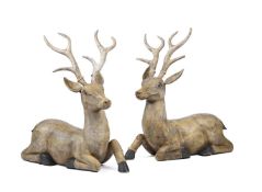 A LARGE PAIR OF CARVED HARDWOOD AND POLYCHROME PAINTED MODELS OF RECUMBENT DEER