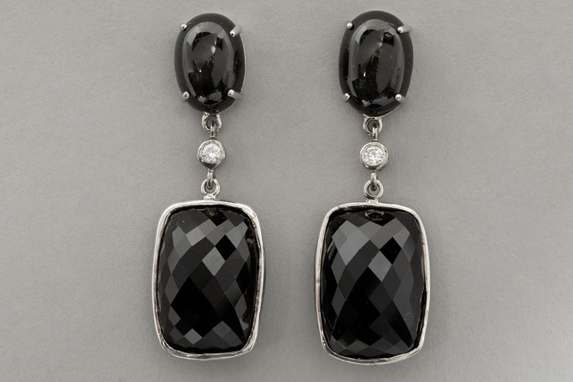 pair of earrings in white gold (18 carat) with two cabochon cut "cat's eyes" , two small high qualit