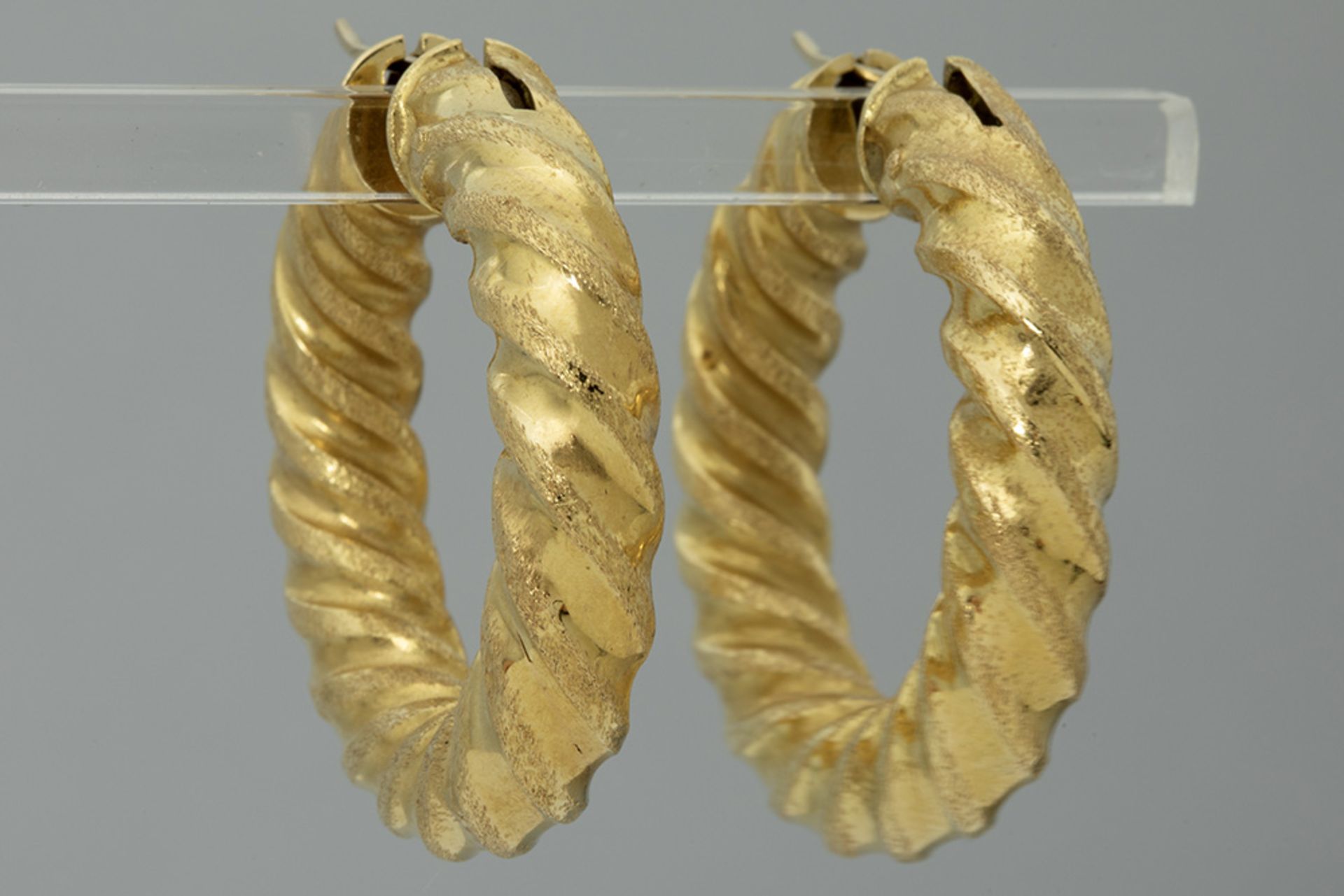 pair of earrings in yellow gold (18 carat) with twisted, partly matted corpus