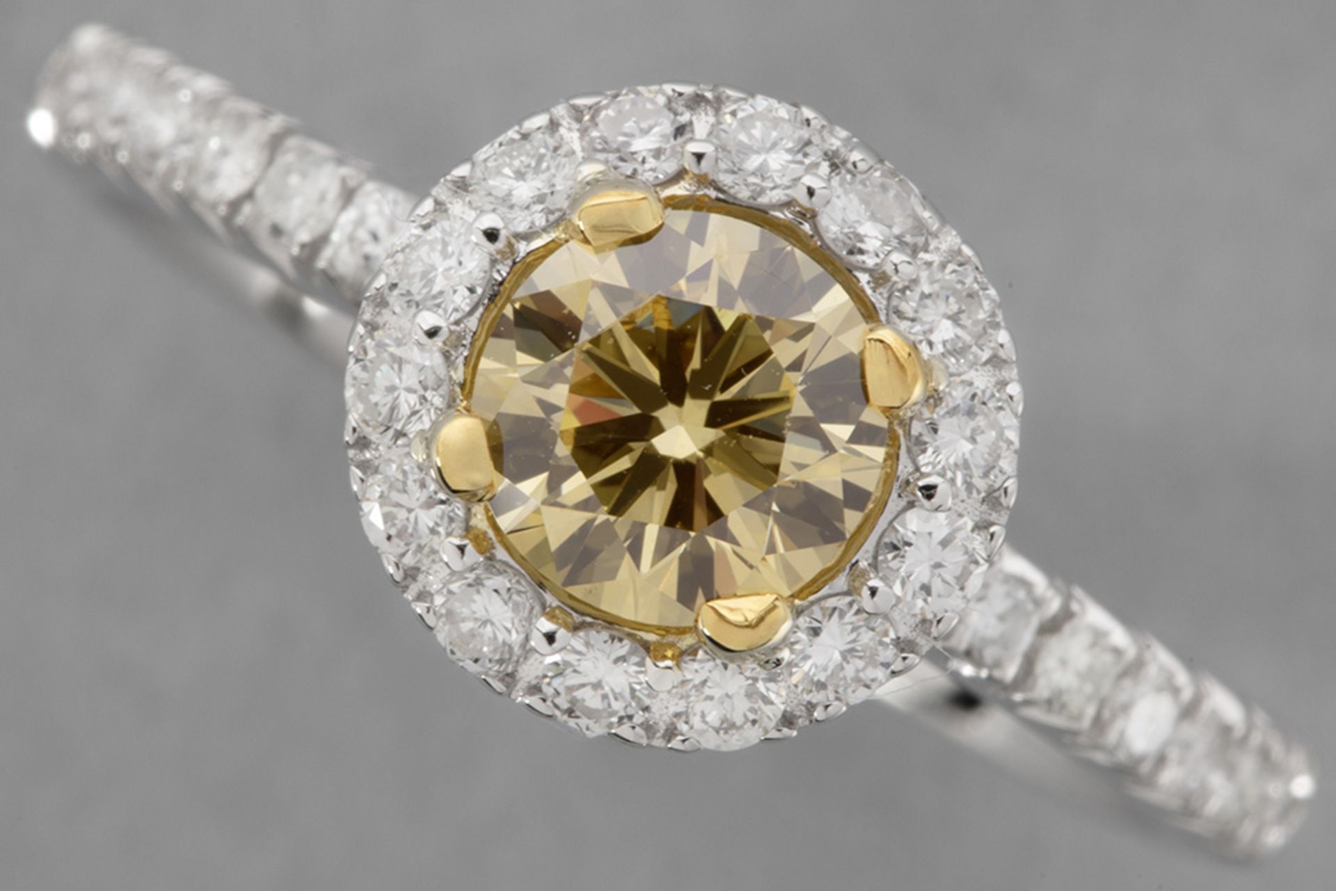 a 0,71 carat natural fancy "Intense Yellow-Orange color high quality brilliant cut diamond set in a 