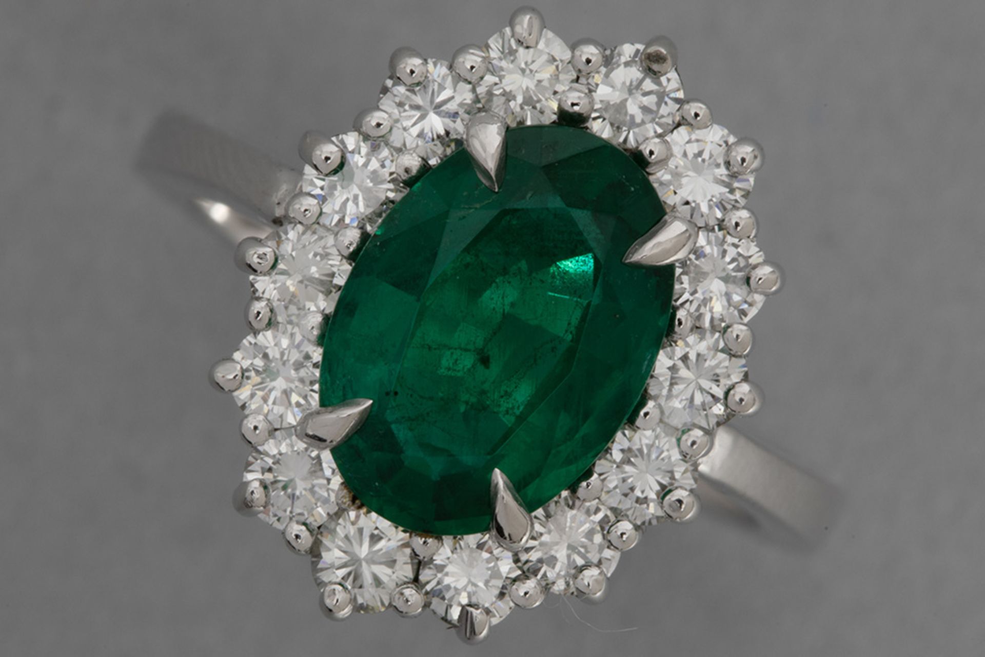 oval cluster ring in platinum with a 2,52 carat Zambian emerald with a very nice color surrounded by
