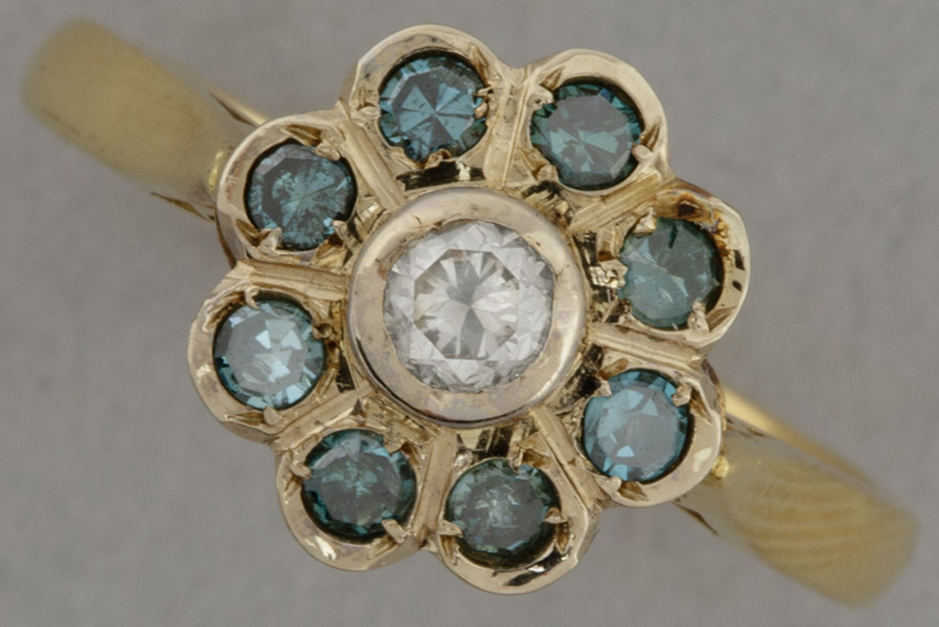 ring in yellow gold (18 carat) with at least 0,55 carat brilliants (one white and eight blue ones)