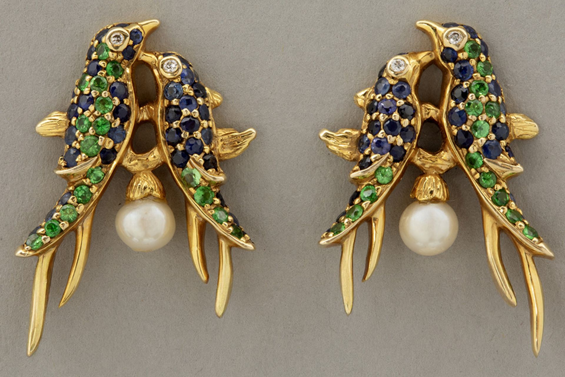 pair of earrings in yellow gold (18 carat) with a cute design with two birds and with tsavarite, sap