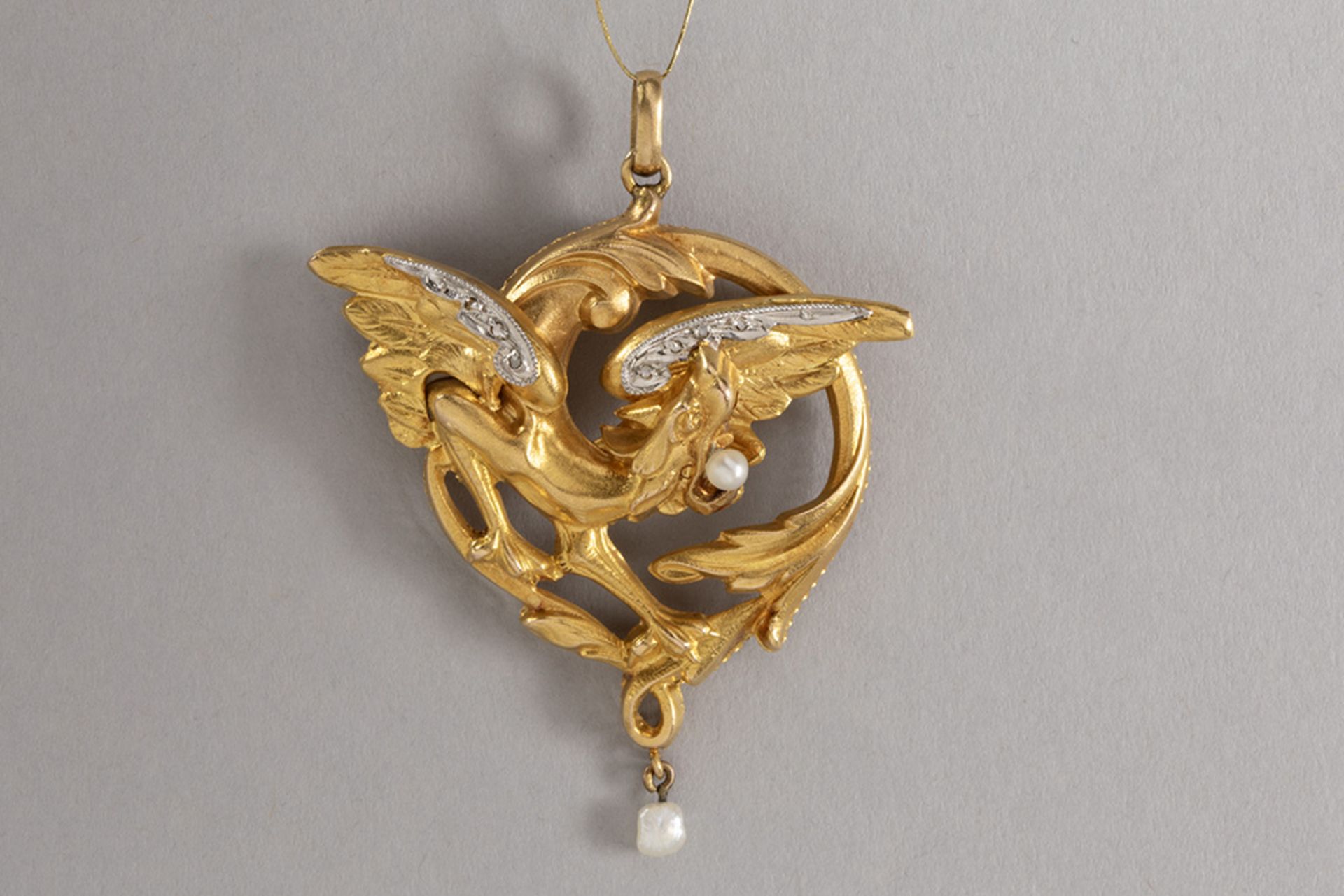 Art Nouveau pendant in yellow gold (18 carat) with a dragon design with a small pearl and diamonds