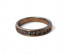 An 18ct white gold half eternity ring, channel set with nine brilliant cut diamonds, total carat