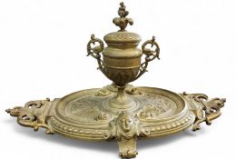 A Victorian bronzed standish, with pedestal two handled urnular well, leafy finial, the oval stand