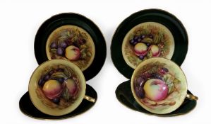 An Aynsley teacups, saucer and side plate, printed with ripe fruit, the exterior in green, printed