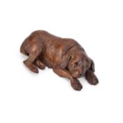 A BLACK FOREST LINDEN WOOD CARVING OF A RECUMBENT DOG LATE 19TH/ EARLY 20TH CENTURY