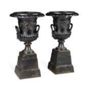A PAIR OF CAST IRON URNS ON STANDS