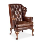 A BROWN LEATHER WING-BACK ARMCHAIR