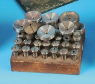 Spannzangen im Holzblock und kleine Spannzangen in runder Dose