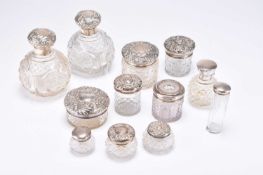 A group of twelve silver topped glass dressing table jars/bottles