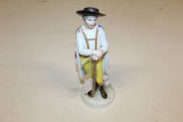 A continental porcelain figure of man with cloak r