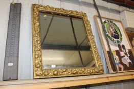 A gilt framed wall mirror having fruit carved deco