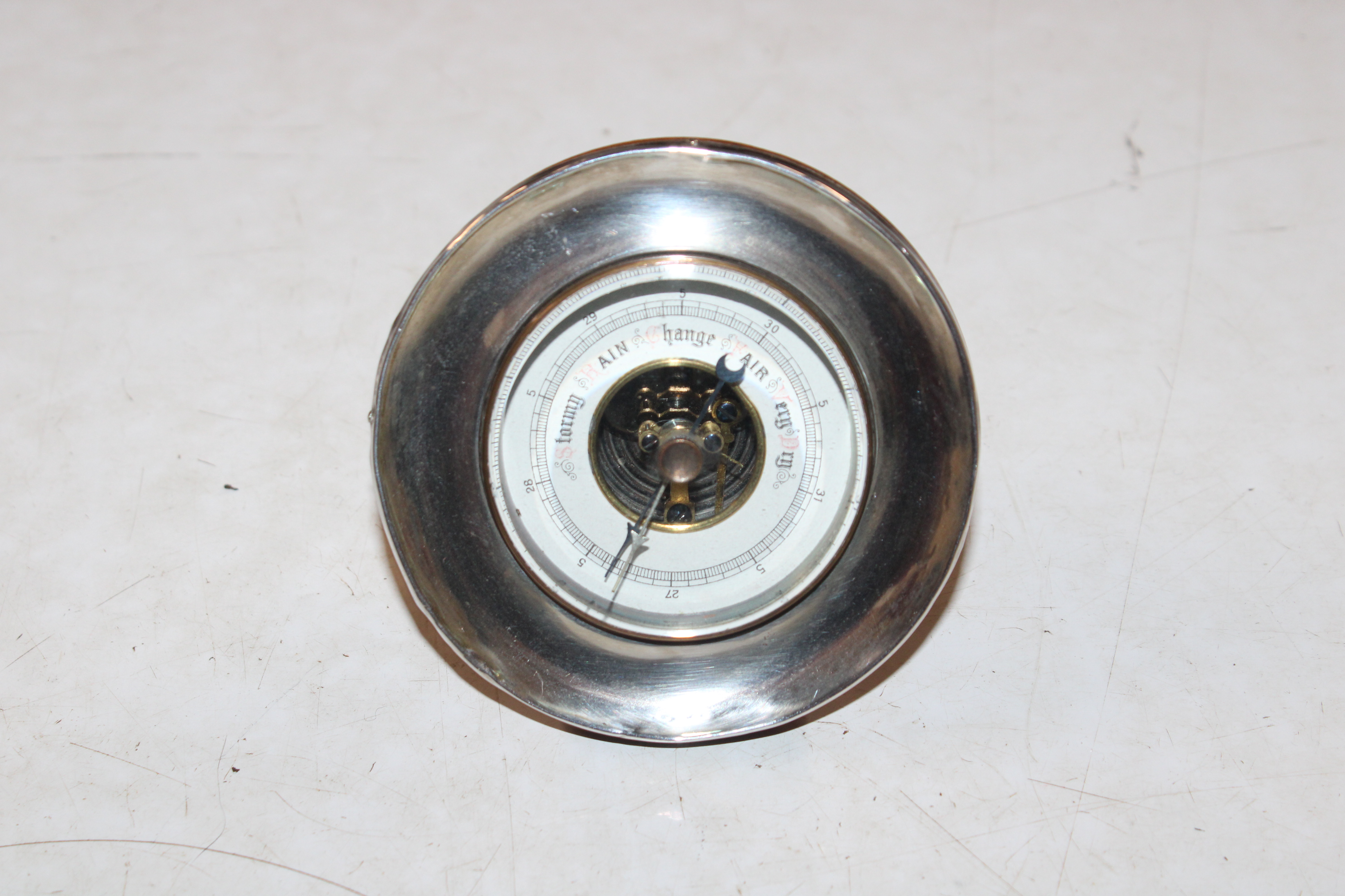 A small circular oak and silver desk barometer, Ha