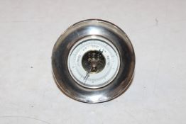 A small circular oak and silver desk barometer, Ha