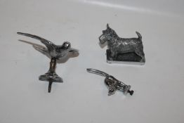 Three car mascots in the form of a dog, bird and c