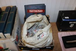 A box containing various loose stamps and a post-c