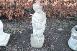 A concrete statue of a seated maiden holding a bir