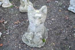 A concrete statue in the form of a seated mother f