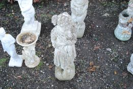 A concrete statue in the form of a scantily clad m