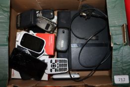A box containing Playstation2, Ipad, various mobi
